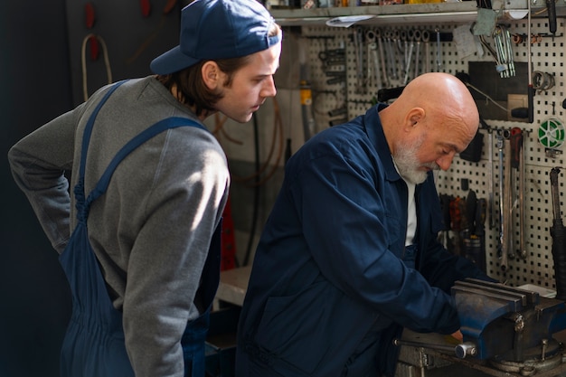 Free photo male car mechanic working in the car repair shop