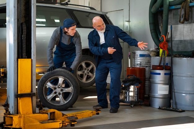 Free photo male car mechanic working in the car repair shop