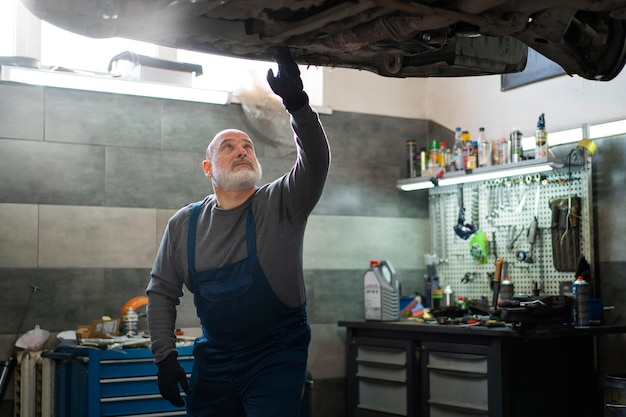 Free Photo male car mechanic working in the car repair shop