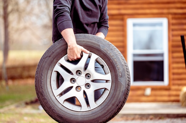 Free photo male carrying a new car tire