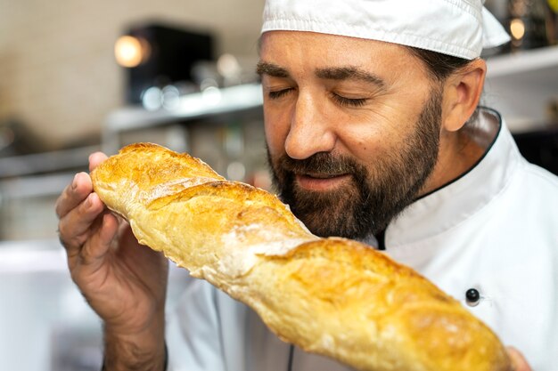 Male chef in the kitchen smelling freshly baked bread