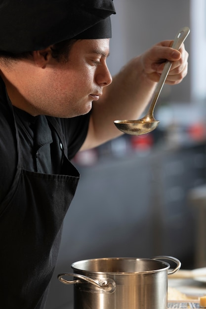 Male chef in kitchen tasting the food