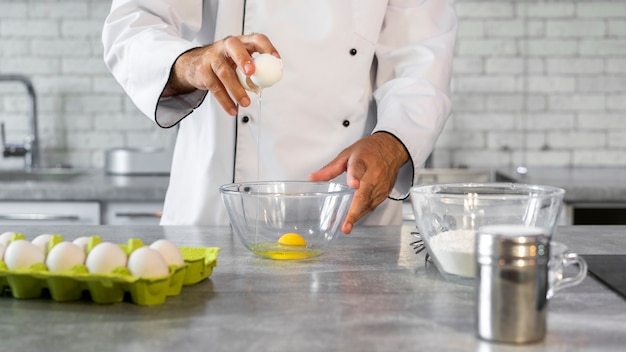 Free photo male chef in the kitchen using eggs to cook