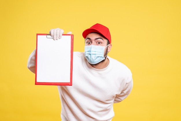 Free Photo male courier in mask holding file note on yellow