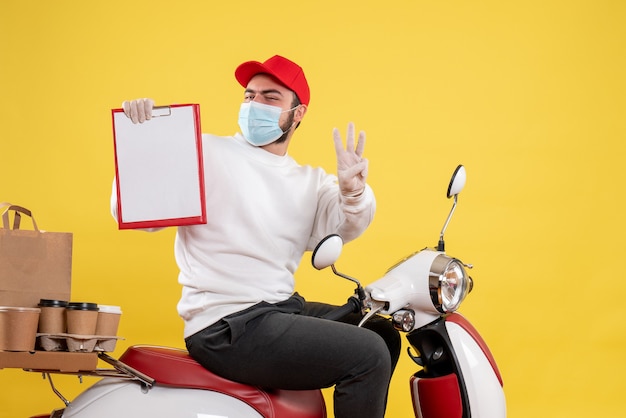 male courier in mask holding file note on yellow