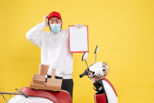 Free photo male courier in sterile mask holding file note on yellow