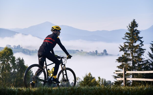 Male cyclist riding bicycle in mountains