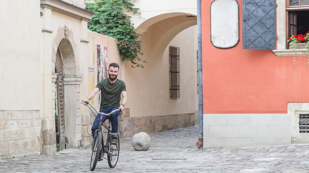 Male cyclist riding bicycle on stone pavement