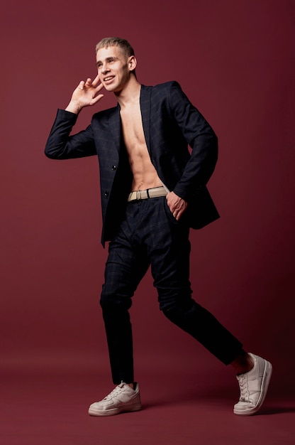 Free photo male dancer posing in sneakers and suit without shirt