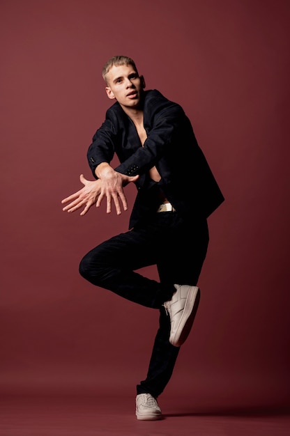 Free photo male dancer in sneakers and suit without shirt busting a hip hop move