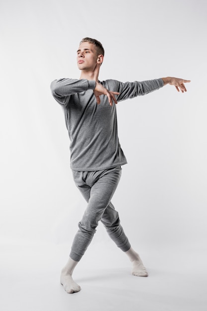 Free Photo male dancer in tracksuit and socks giving ballet pose