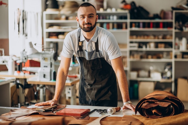 Male designer and leather tailor working at a factory