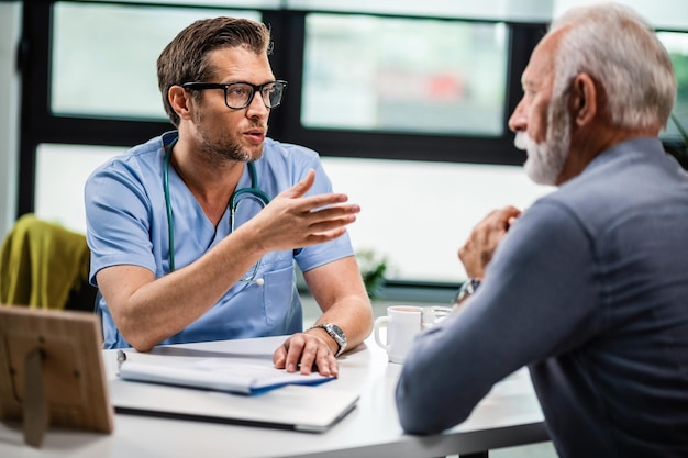 Free photo male doctor communicating with senior patient during medical consultations at his office