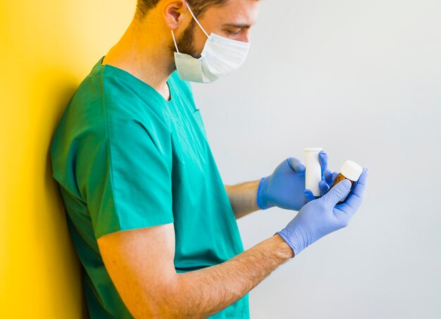 Male doctor holding medicine bottles 