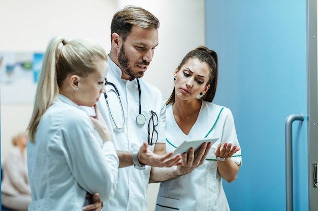 Free Photo male doctor and nurses communicating while working on digital tablet at clinic