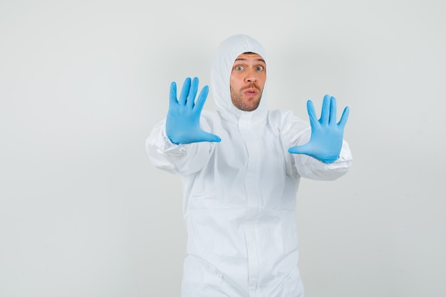 Free photo male doctor showing stop gesture in protective suit