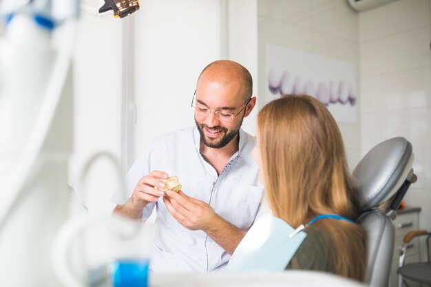 Male doctor talking to patient showing dental jaw