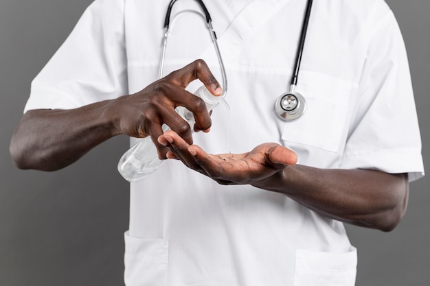 Male doctor using hand sanitizer for his safety