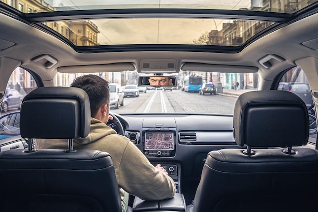 A male driver drives at speed through the streets of the city