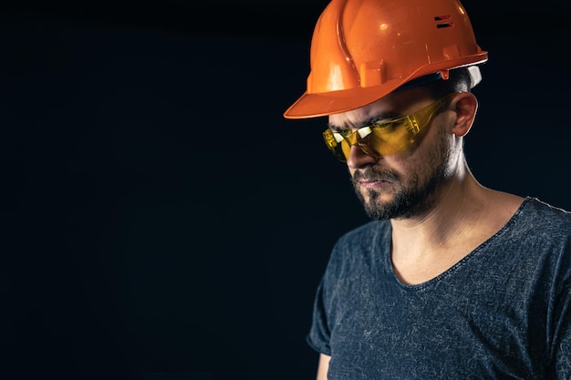 Free photo male electrician in a protective helmet with glasses on a black background