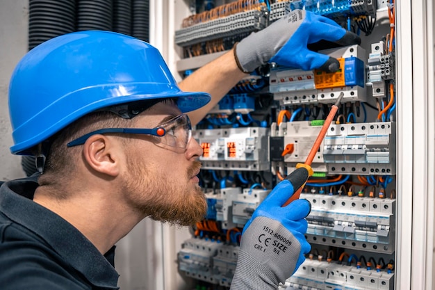 Free photo male electrician working in a switchboard with fuses