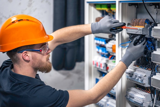 Free photo male electrician working in a switchboard with fuses