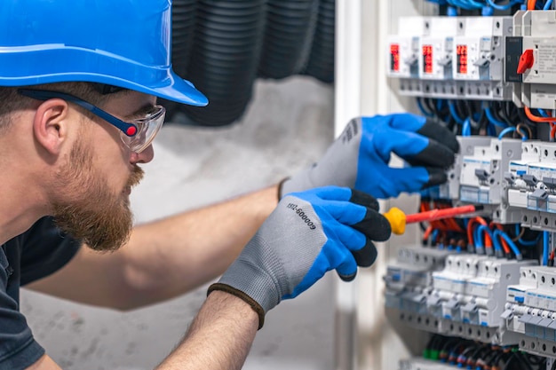 Free photo male electrician working in a switchboard with fuses