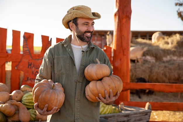 Male farmer holding pumpkin harvest at the farm