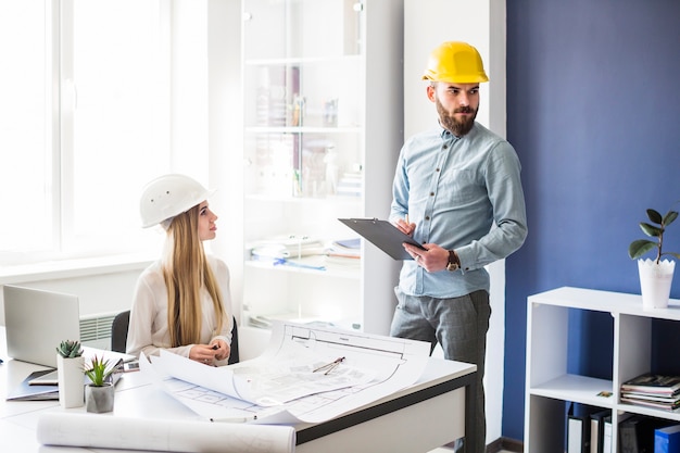 Free photo male and female architect working in the office