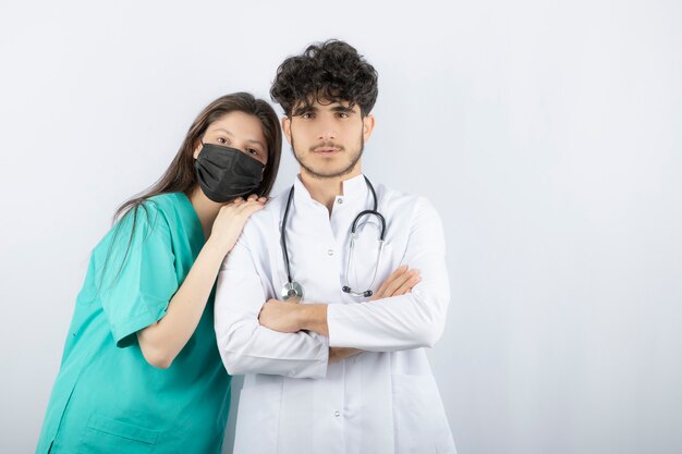 Male and female doctors standing and looking at camera . 