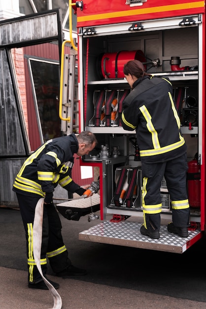 Male and female firefighters at the station working together