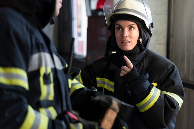 Free photo male and female firefighters working together in suits and helmets