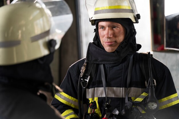 Male and female firefighters working together in suits and helmets