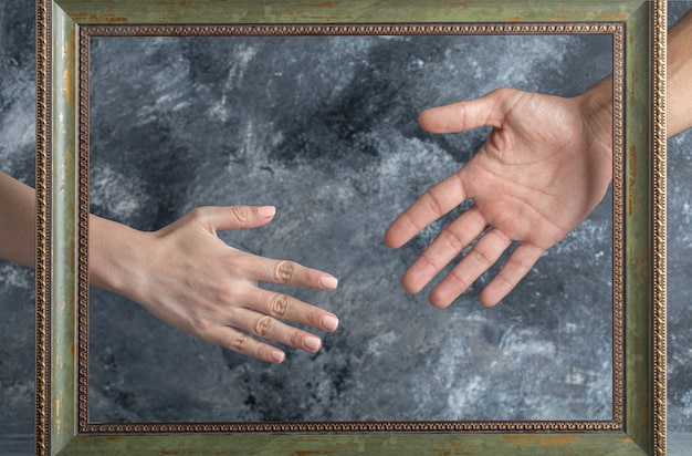 Male and female showing hands in middle of picture frame.