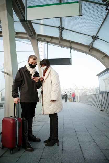 Male and female tourists checking their smartphone outdoors