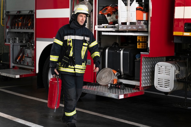 Male firefighter at station equipped with suit and safety helmet