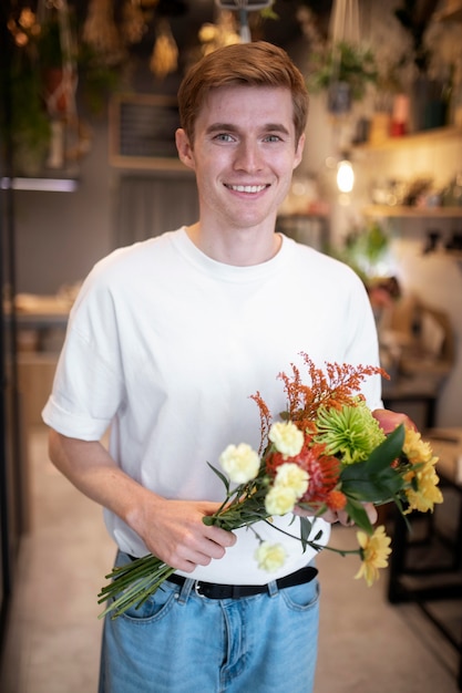 Free photo male florist holding a beautiful bouquet