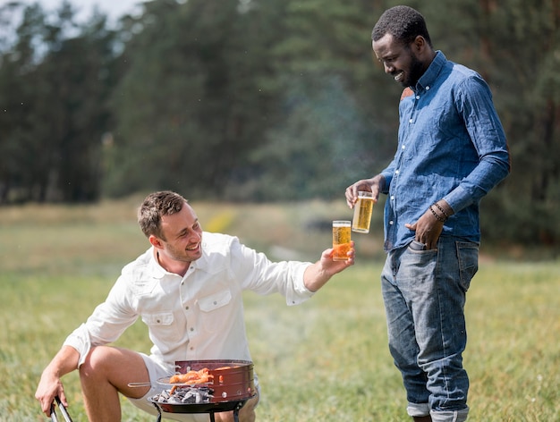 Male friends attending the barbecue outdoors