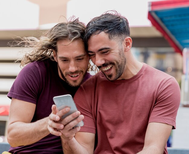 Male friends sitting and watching on mobile