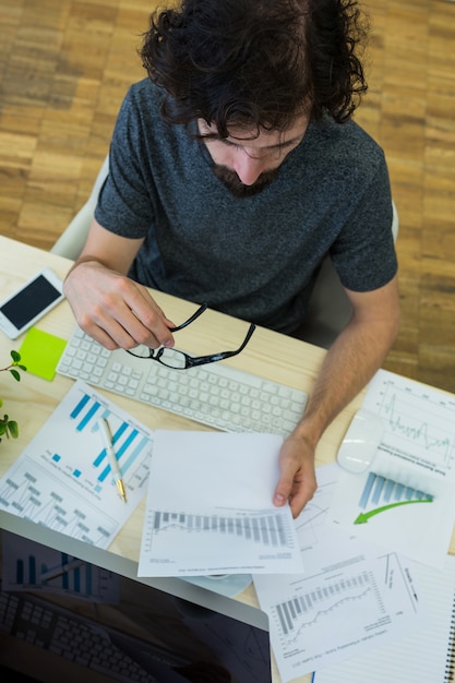 Free photo male graphic designer looking at graph document