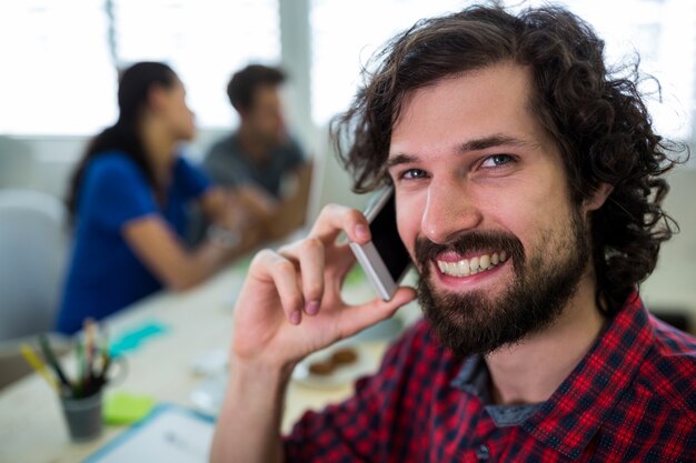 Male graphic designer talking on mobile phone