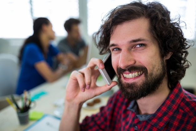 Male graphic designer talking on mobile phone