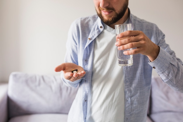 Free Photo male in grey will pills and glass of water