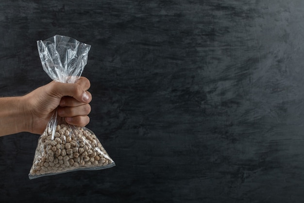 Male hand holding a stack of raw dried peas.