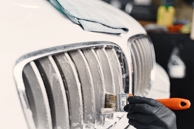 Male hand with foam sponge washing car