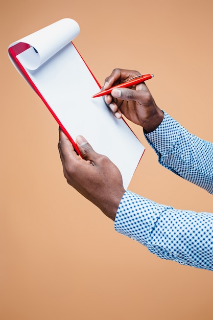 Male hand writing on blank clipboard, isolated