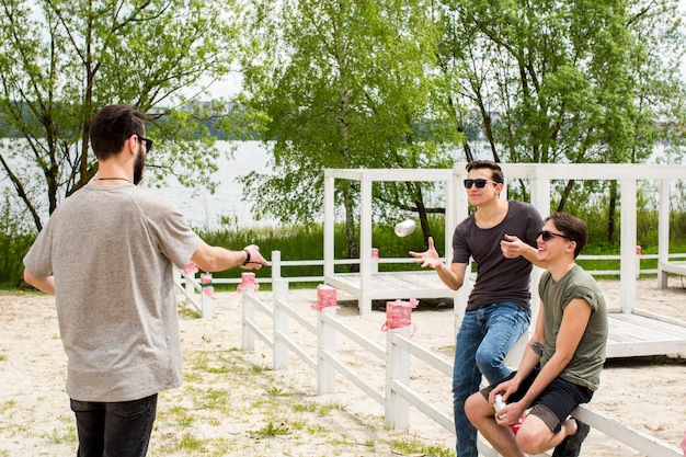 Free photo male handing beer to friends