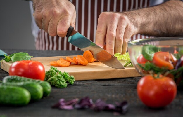 Male hands cutting vegetables for salad