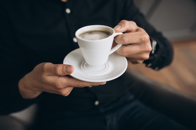 Male hands holding cup of coffee