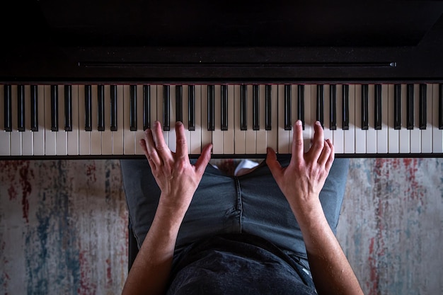 Free photo male hands on the piano keys top view